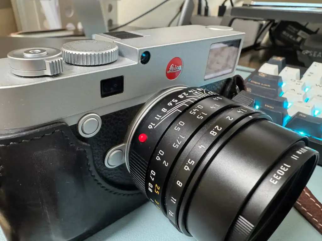 라이카 M 바디와 Summilux 렌즈의 붉은 점이 함께 보이는 근접 사진으로, 라이카 시스템의 정체성과 신뢰를 상징하는 디자인 요소가 강조된 장면