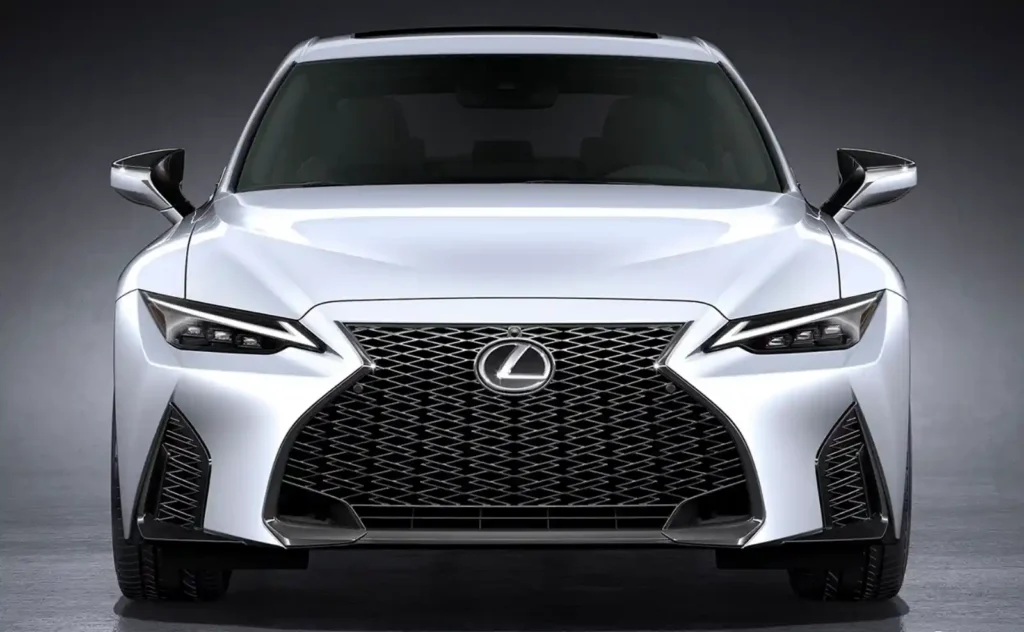 최신 렉서스 세단 정면, 화이트 펄 색상에 스핀들 그릴과 날카로운 LED 헤드램프가 돋보이는 모습