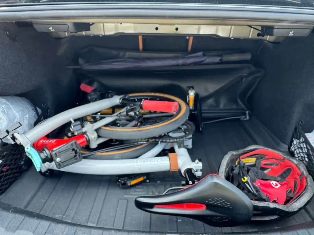 BMW M340i 트렁크 안쪽에 깊숙하게 적재된 브롬톤 자전거와 헬멧, 그리고 넓게 남은 여유 공간