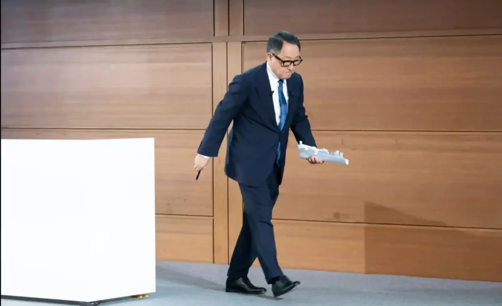 2023년 마지막 주주총회 연설을 마치고 무대를 내려가는 도요다 아키오의 뒷모습, 손에 연설문을 들고 있음