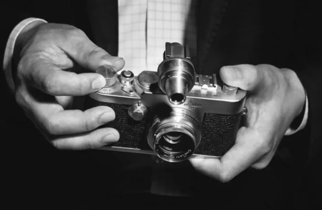 라이카 M 필름 카메라로 레인지파인더를 들여다보는 사진가의 손 - 흑백