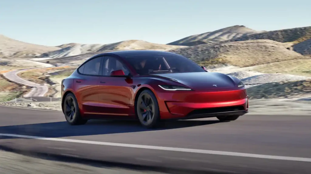 테슬라 모델 3 퍼포먼스가 와인딩 로드를 주행하는 모습 - 레드 투톤 컬러의 역동적인 주행 장면