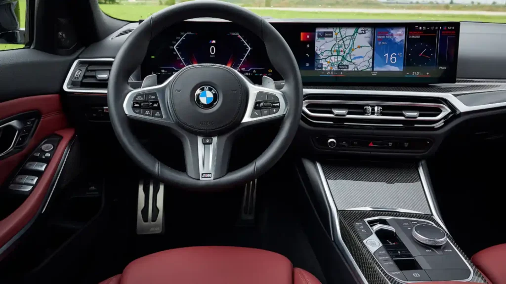 BMW M340i 실내 - M 스티어링 휠, 커브드 디스플레이, iDrive 컨트롤러, 레드 가죽 시트가 특징인 운전석 뷰