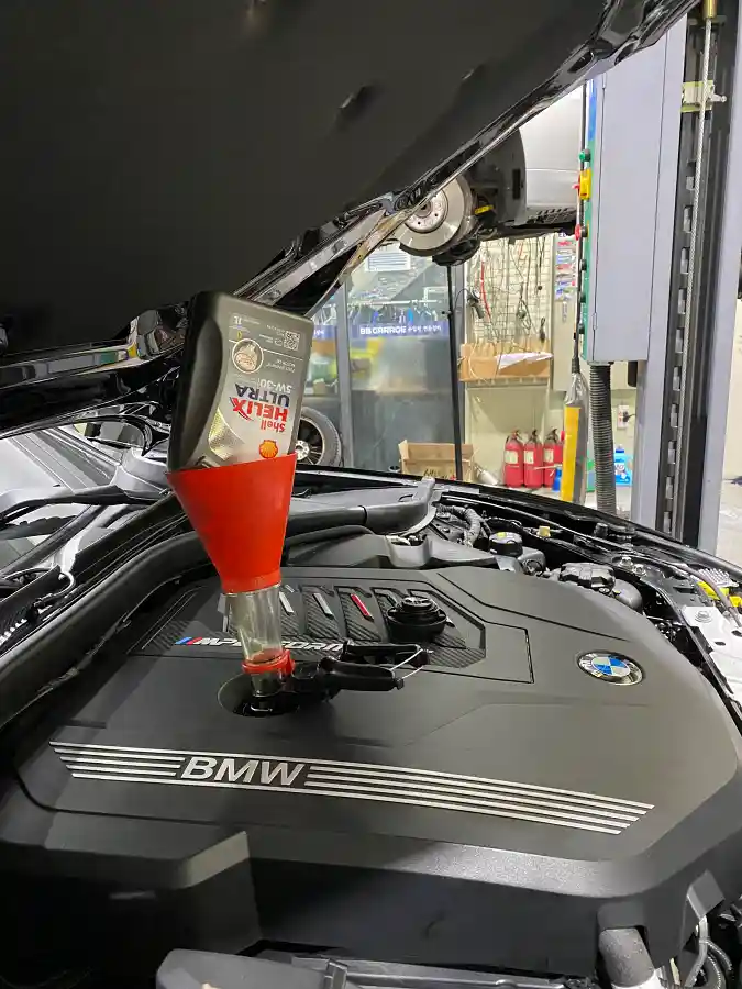 BMW M340i 엔진 오일 교환 중 - Shell Helix Ultra 엔진 오일이 주입되고 있는 직렬 6기통 엔진룸