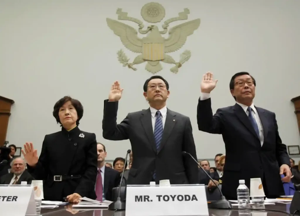 2010년 미국 의회 청문회에서 선서하는 도요다 아키오와 토요타 임원들, 배경에 미국 국장이 보이며 MR. TOYODA 명패가 앞에 놓여있음