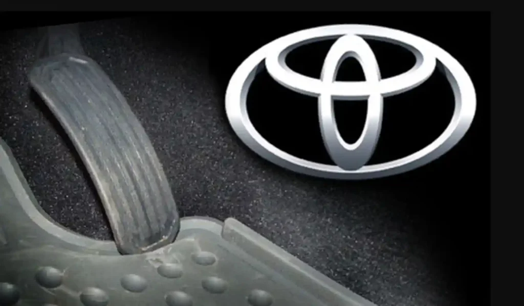 토요타 차량 내부 플로어 매트와 가속 페달, 토요타 로고와 함께 리콜 사태의 시작점이 된 설계 문제를 보여줌