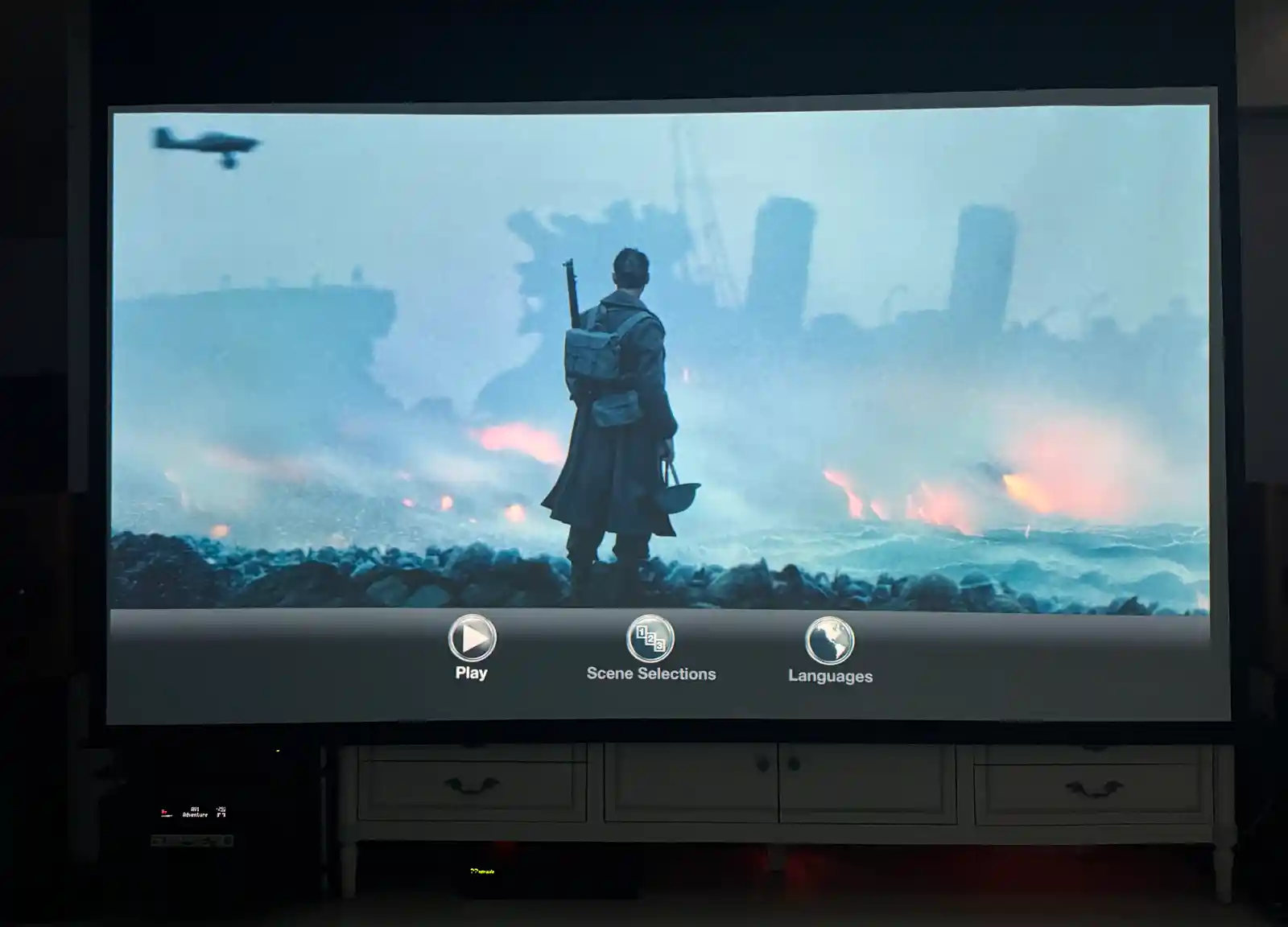 5.1.4채널 홈시어터에서 블루레이 영화가 상영 중인 화면과 양쪽 스피커 전경