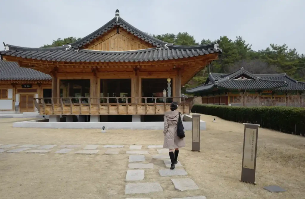 한옥 건물 앞 마당을 걷는 인물을 28mm 화각으로 담은 사진, 넓은 공간과 인물이 함께 프레임에 들어온 장면