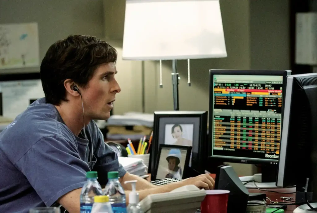 빅쇼트 스틸컷, 마이클 버리(크리스찬 베일)가 블룸버그 금융 데이터 화면 앞에서 서브프라임 모기지 시장을 분석하는 모습