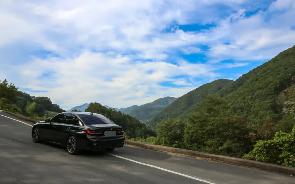 산악 도로를 달리는 BMW M340i 실차 후면 사진