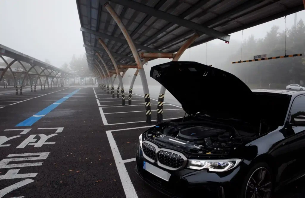 국내 주차장에서 후드를 열어 엔진룸을 드러낸 BMW M340i 실차 사진