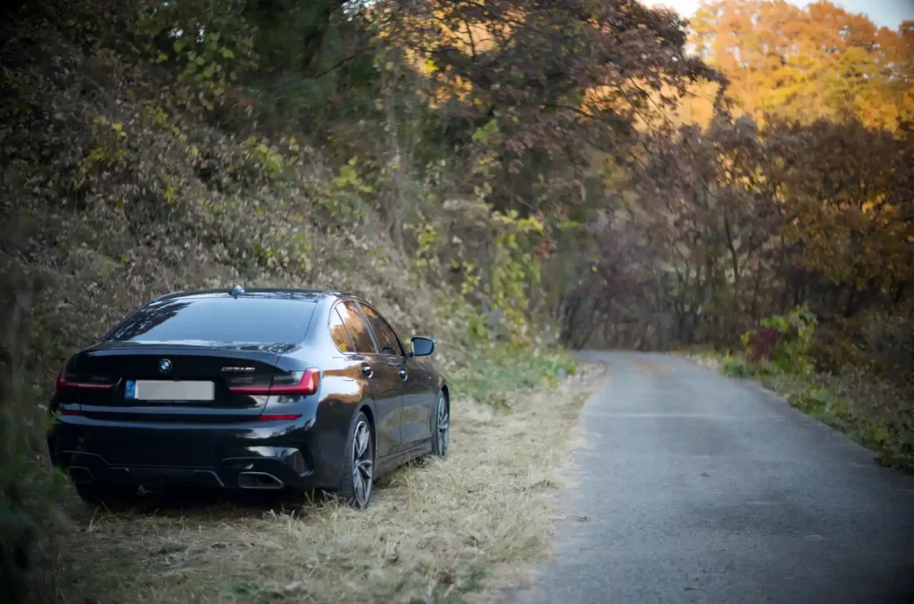 가을 단풍길 갓길에 세워진 BMW M340i 실차 후면 사진