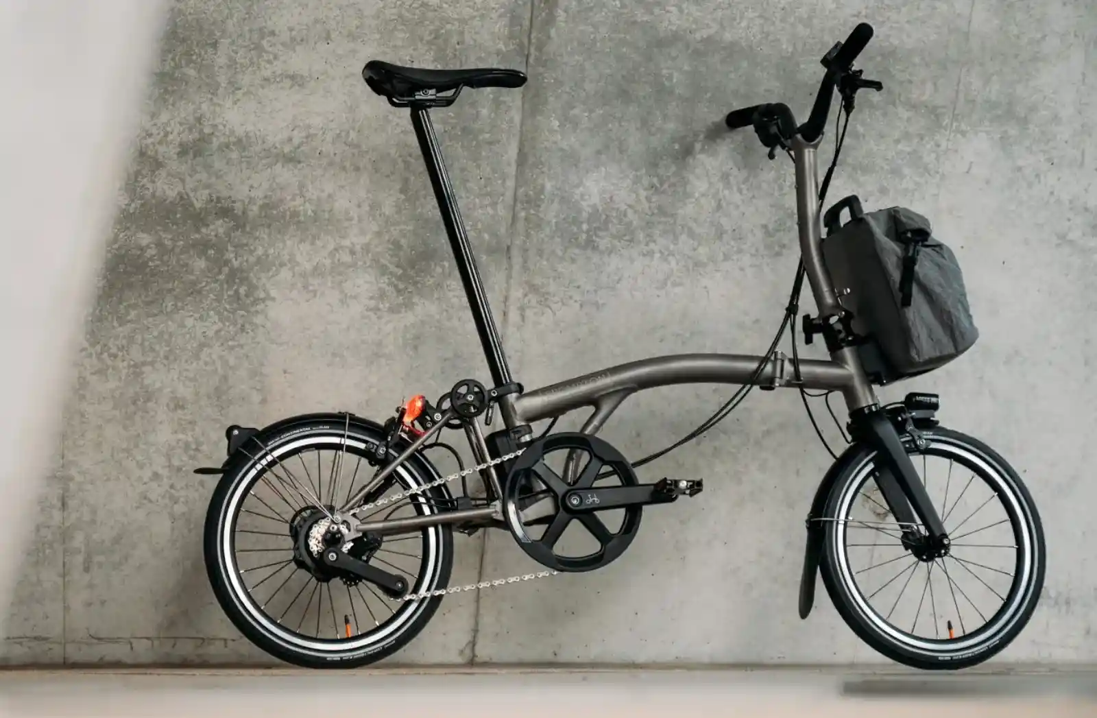 브롬톤 Electric T Line 티타늄 컬러 측면 전체 샷 — 리어 허브 모터와 프론트 배터리 백 장착 상태