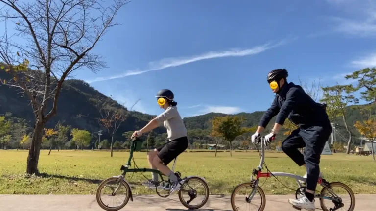 브롬톤 자전거를 타는 두 사람. 왼쪽은 따우전드 어반 헬멧, 오른쪽은 로드용 에어로 헬멧을 착용하고 있다.