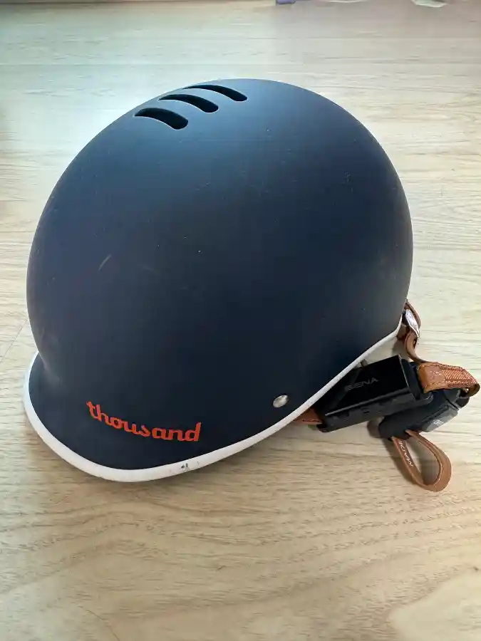 네이비 컬러 따우전드 헤리티지 헬멧 실물 사진. 측면에 세나 블루투스 액세서리가 장착되어 있다.