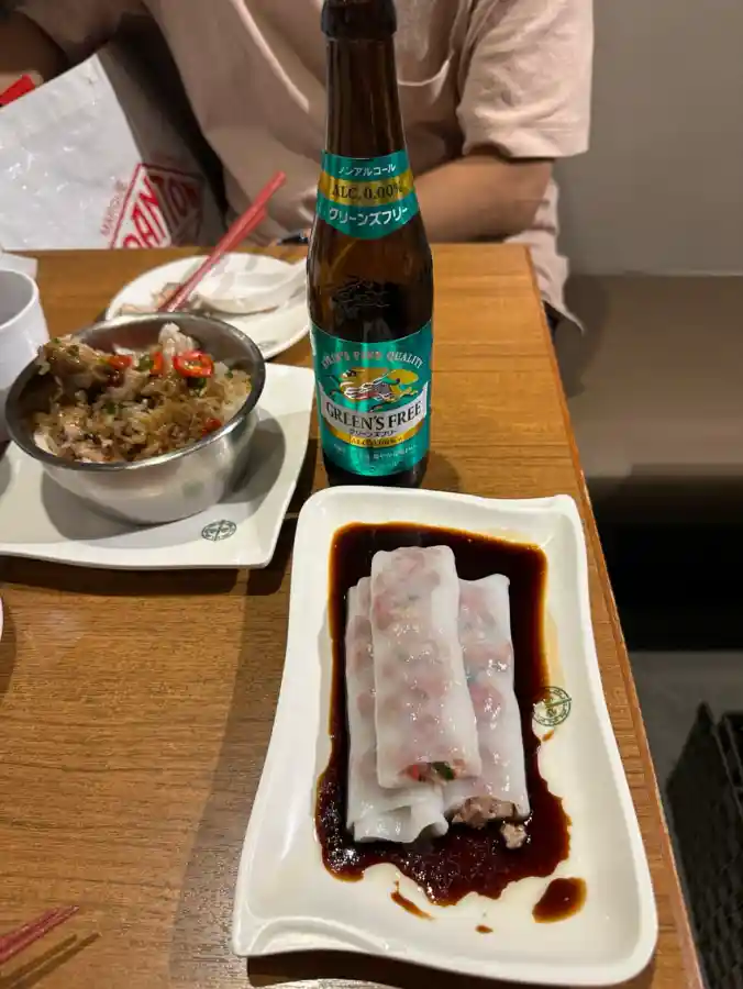 팀호완 챠슈 라이스롤과 돼지갈비 찜밥, 간장 소스가 깔린 접시와 스테인리스 그릇