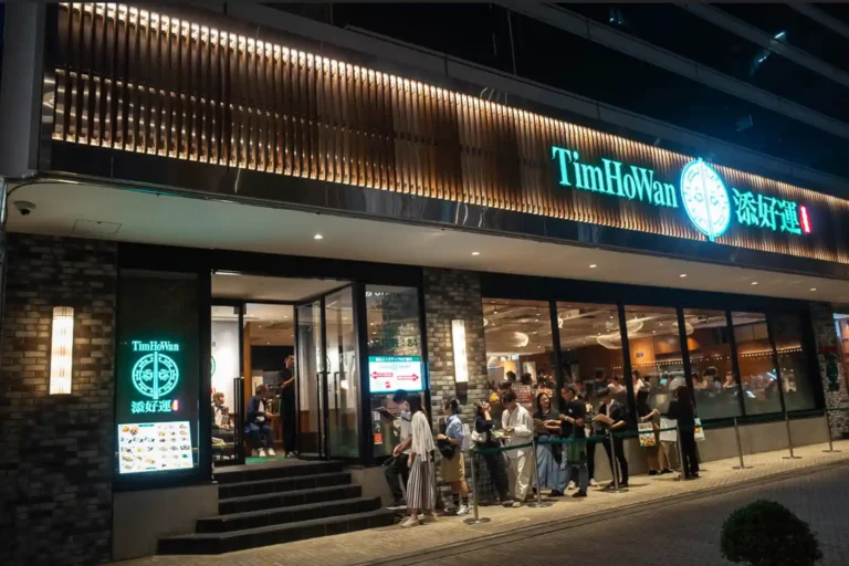 도쿄 히비야 팀호완 외관 야경, 입구 앞 웨이팅 줄과 녹색 네온 간판