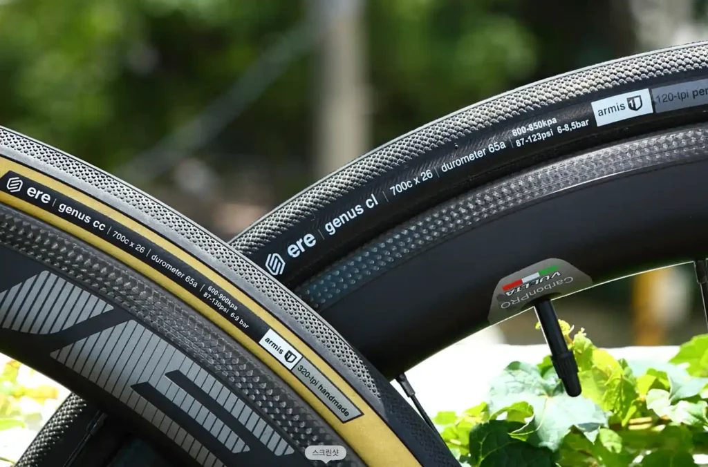 ere genus cc와 genus cl 로드바이크 타이어 두 개를 나란히 놓은 클로즈업 사진, 사이드월에 700c x 26 스펙 표기가 선명하게 보임