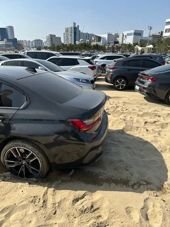 포항 영일대 공용주차장 모래 노면에 매몰된 BMW M340i 뒷바퀴 — 후륜구동 차량이 모래를 파고들며 정지한 모습