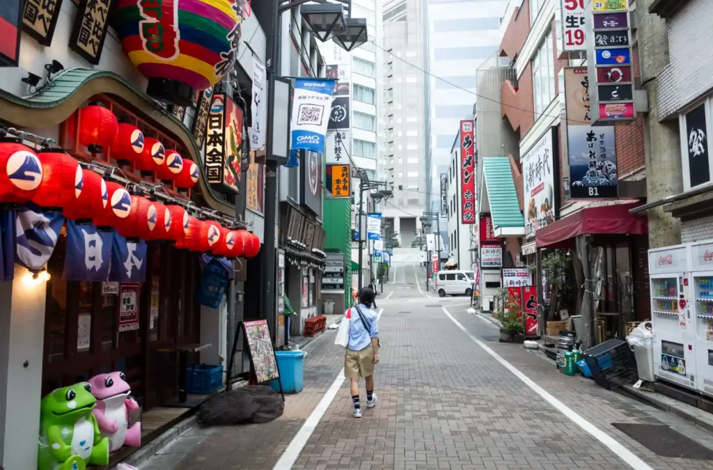 시부야 이자카야 골목에 붉은 제등이 줄지어 걸린 가운데 혼자 걷는 와이프의 뒷모습