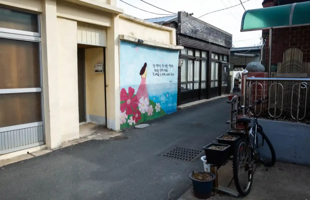 욕지도 욕지반점 가는 길 — 벽화가 그려진 좁은 골목길과 세워진 자전거