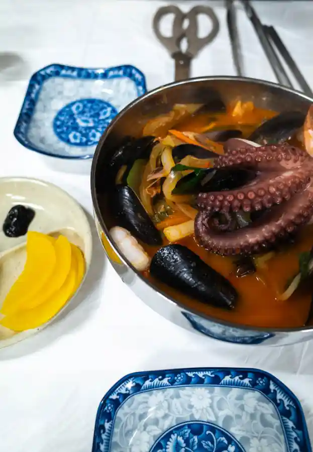 욕지반점 돌문어 짬뽕 — 그릇 위로 올라온 욕지도산 돌문어 다리 클로즈업