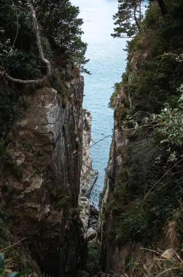 욕지도 고래강정 전경, 바다 쪽으로 깊고 좁게 패인 절벽 골짜기 사이로 푸른 한려수도 바다가 내려다보이는 풍경