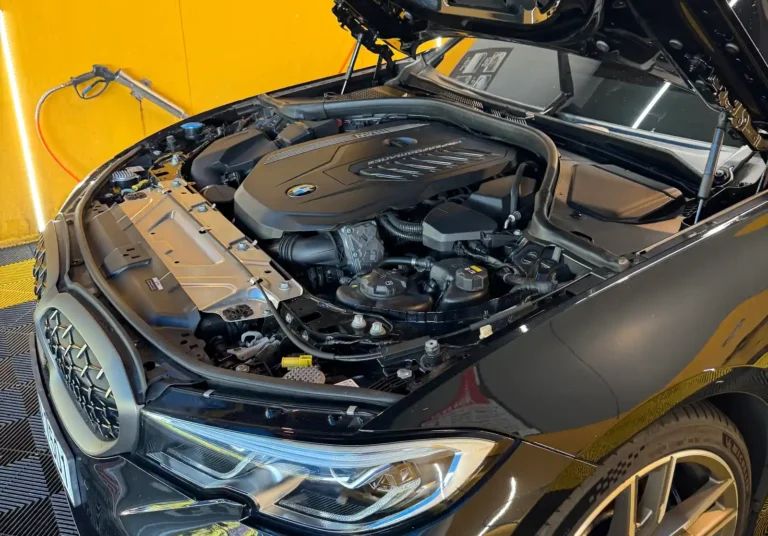 BMW M340i 엔진룸 — 후드를 열어 드러난 B58 직렬 6기통 엔진 커버와 M Performance 각인