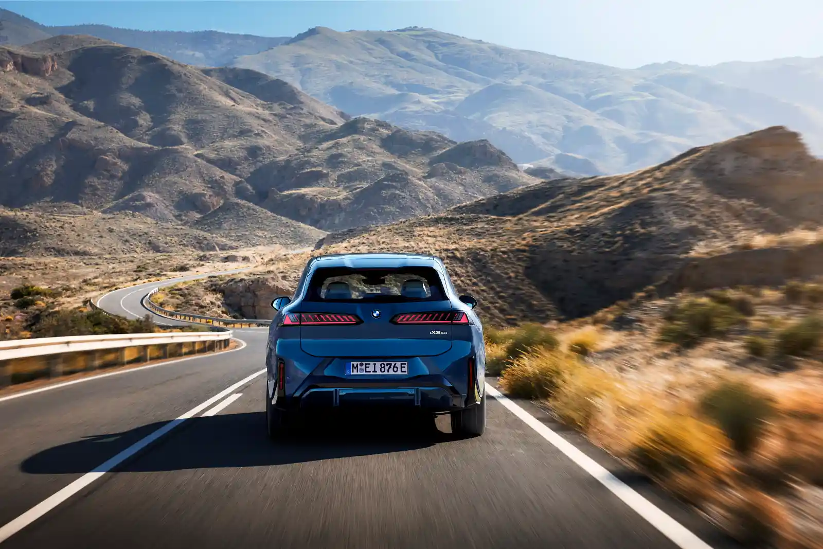 BMW iX3 50 xDrive 후면 주행 사진 — 오션 웨이브 블루 메탈릭