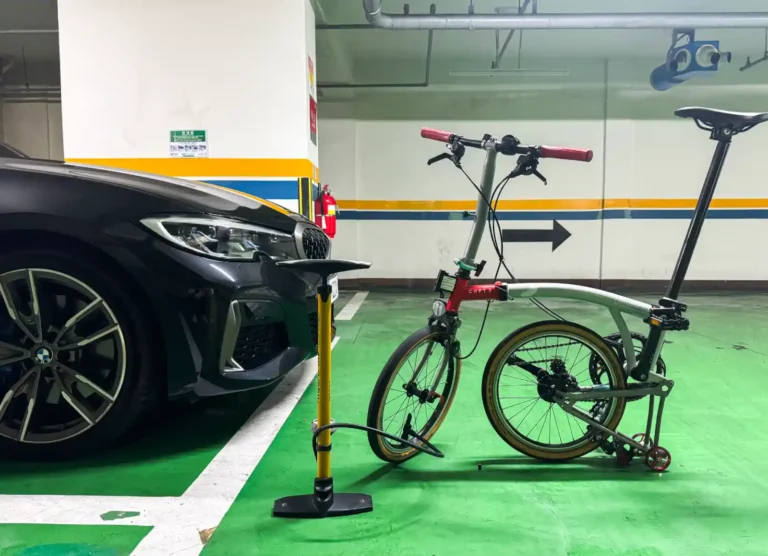 지하 주차장에서 BMW M340i 옆에 세워진 브롬톤 CHPT3 V4와 자전거 공기펌프