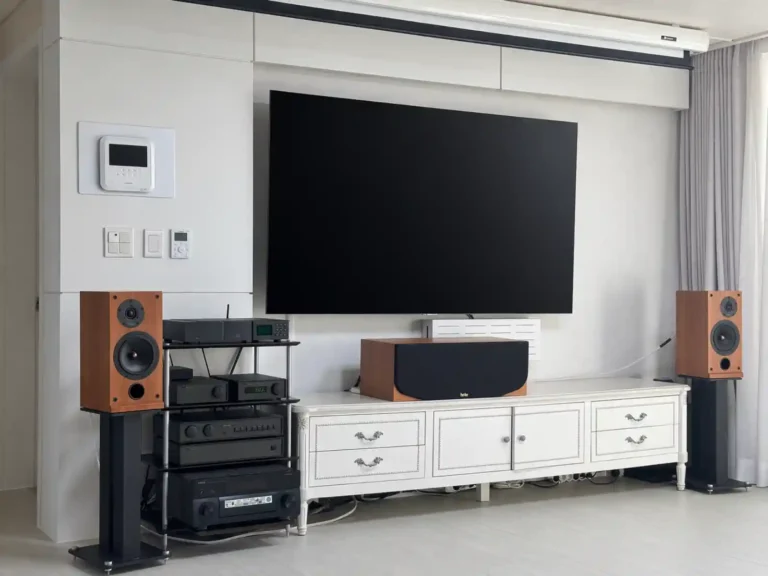거실에 세팅된 Naim 시스템과 ProAc D2 스피커 전경. 블랙 랙에 NDX, nDAC, NAC 102, NAP 180이 적층되어 있고, 체리 우드 마감의 ProAc D2가 스탠드 위에 배치되어 있습니다.