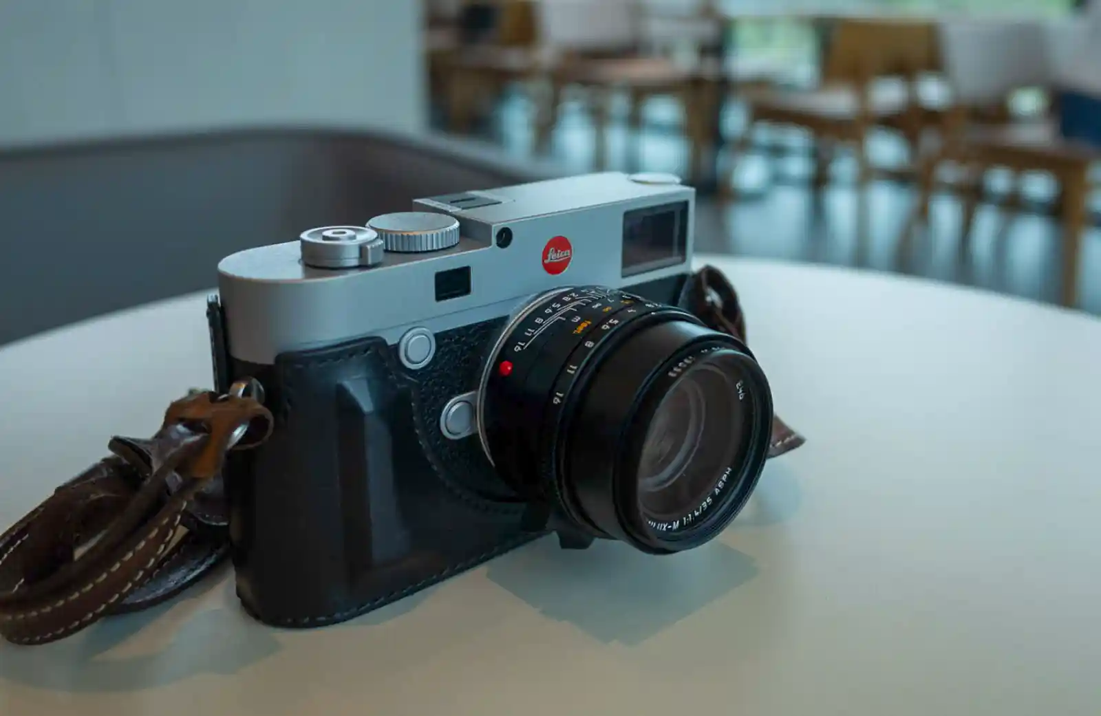 라이카 M10-R 실버 크롬에 주미룩스 35mm f/1.4 렌즈를 장착한 모습, 흰 테이블 위