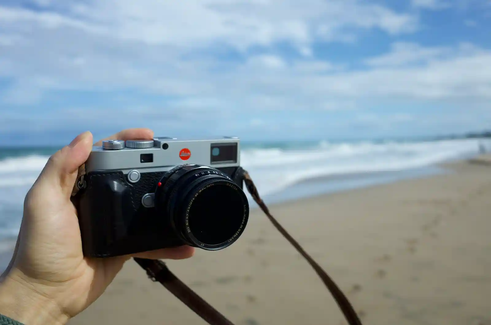 해변에서 라이카 M10-R을 손에 들고 있는 모습