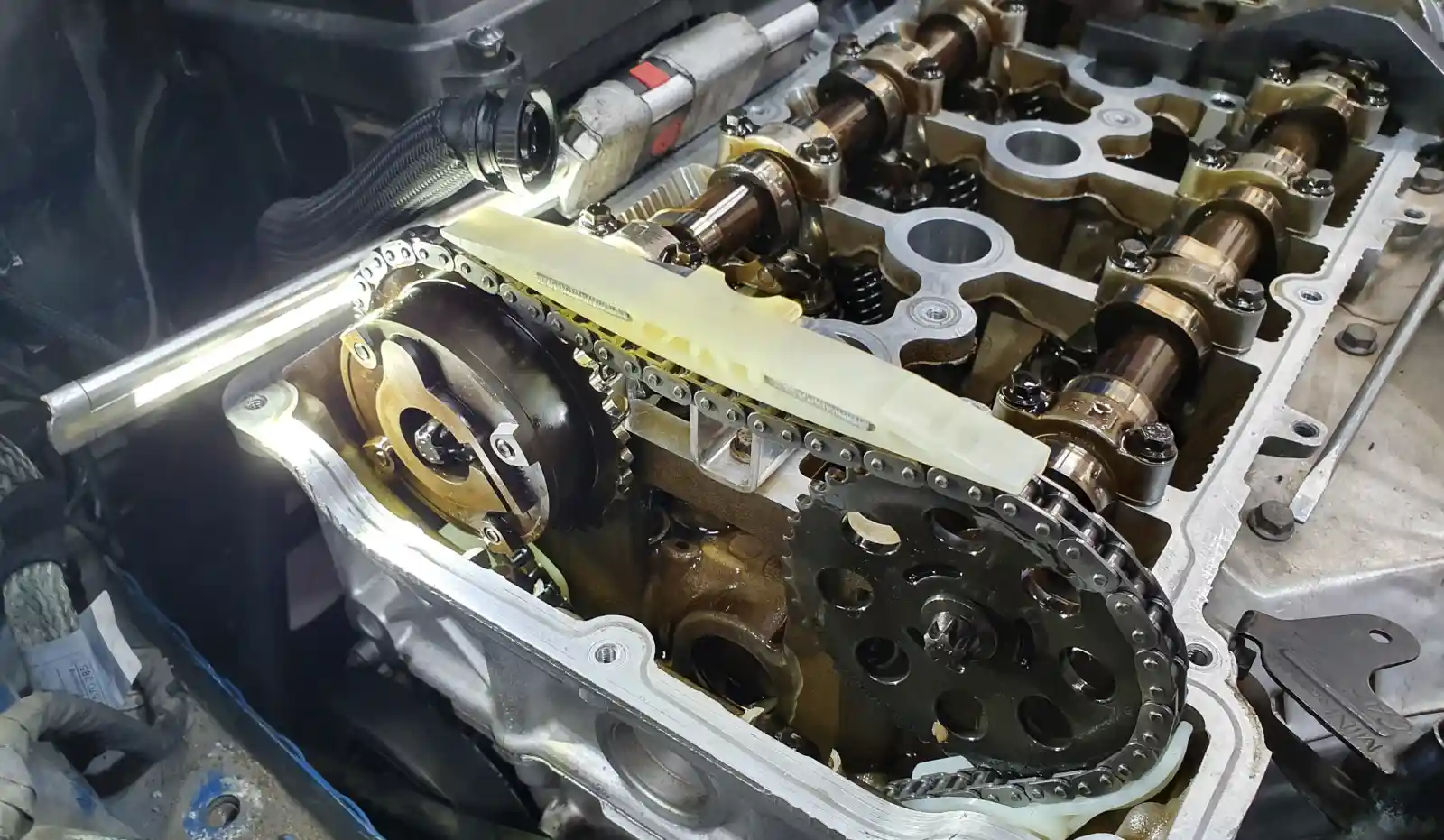 미니 R56 엔진 분해 후 노출된 타이밍체인과 캠 스프로켓, 플라스틱 체인 가이드