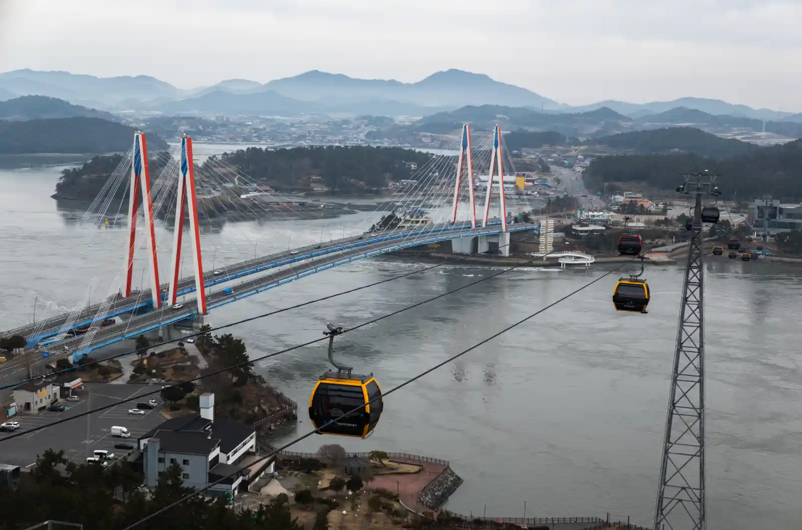 목포 해상케이블카 곤돌라에서 내려다본 목포대교 전경, 회색빛 바다 위로 붉은 주탑 사장교와 노란 곤돌라가 보이는 풍경
