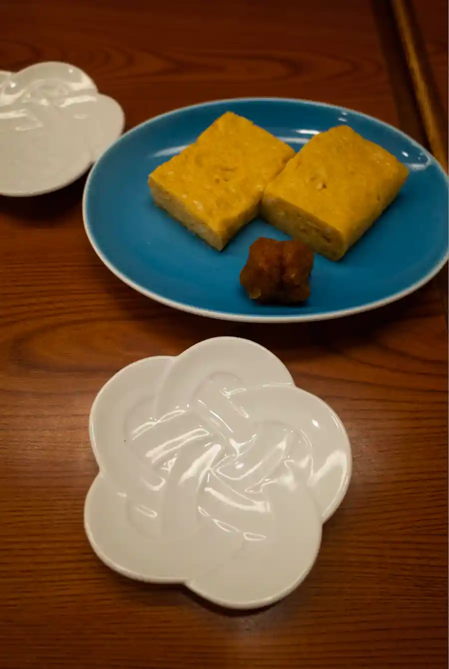 사라시나 호리이 타마고야끼로, 파란 접시 위에 두툼하게 구운 일본식 계란말이 두 조각이 담겨 있다
