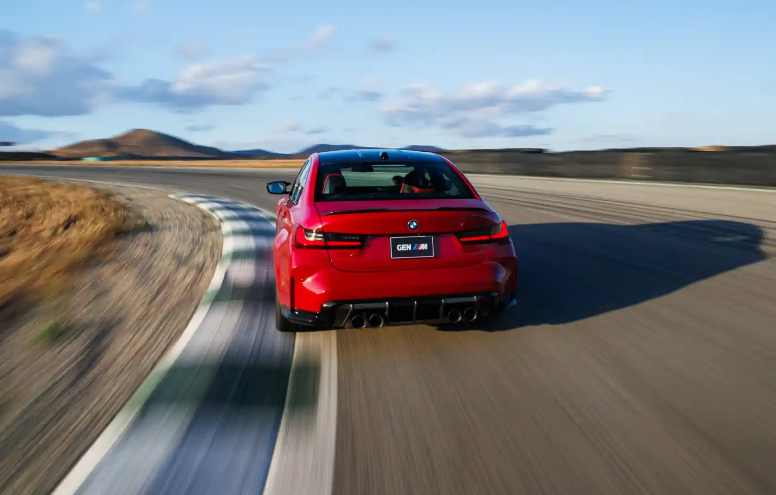 BMW M3 CS Handschalter 리어 주행 — 서킷을 달리는 Imola Red 후면, CFRP 디퓨저와 4구 머플러