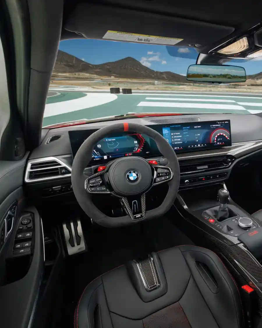 BMW M3 CS Handschalter 운전석 실내 전경 — 클러치 페달과 6단 기어 레버, 서킷 배경