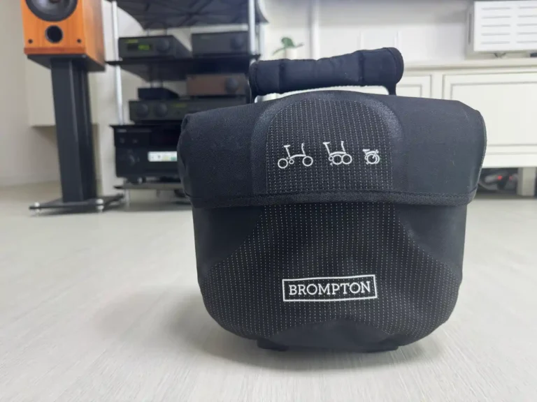 브롬톤 Mini O Bag 블랙 — 접이식 픽토그램과 BROMPTON 로고가 새겨진 프론트 백 정면