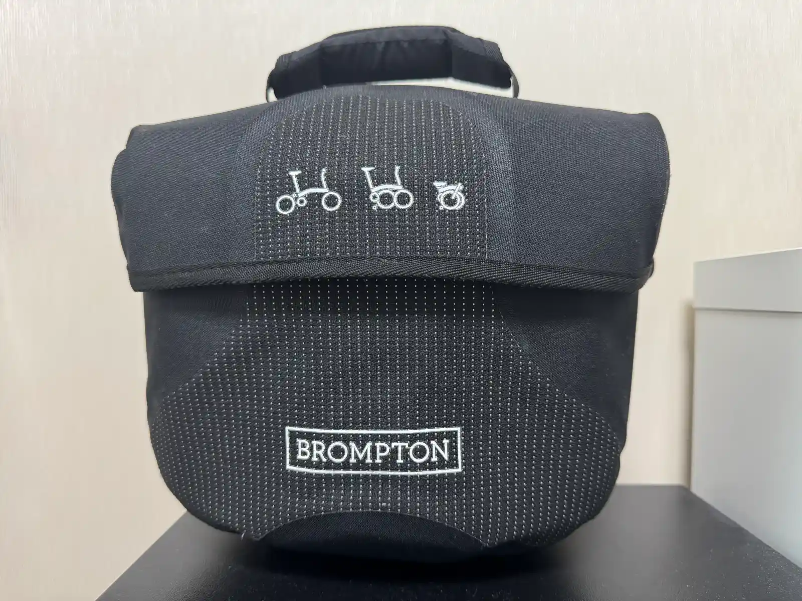 브롬톤 Mini O Bag 블랙 정면 — BROMPTON 로고와 접이식 픽토그램