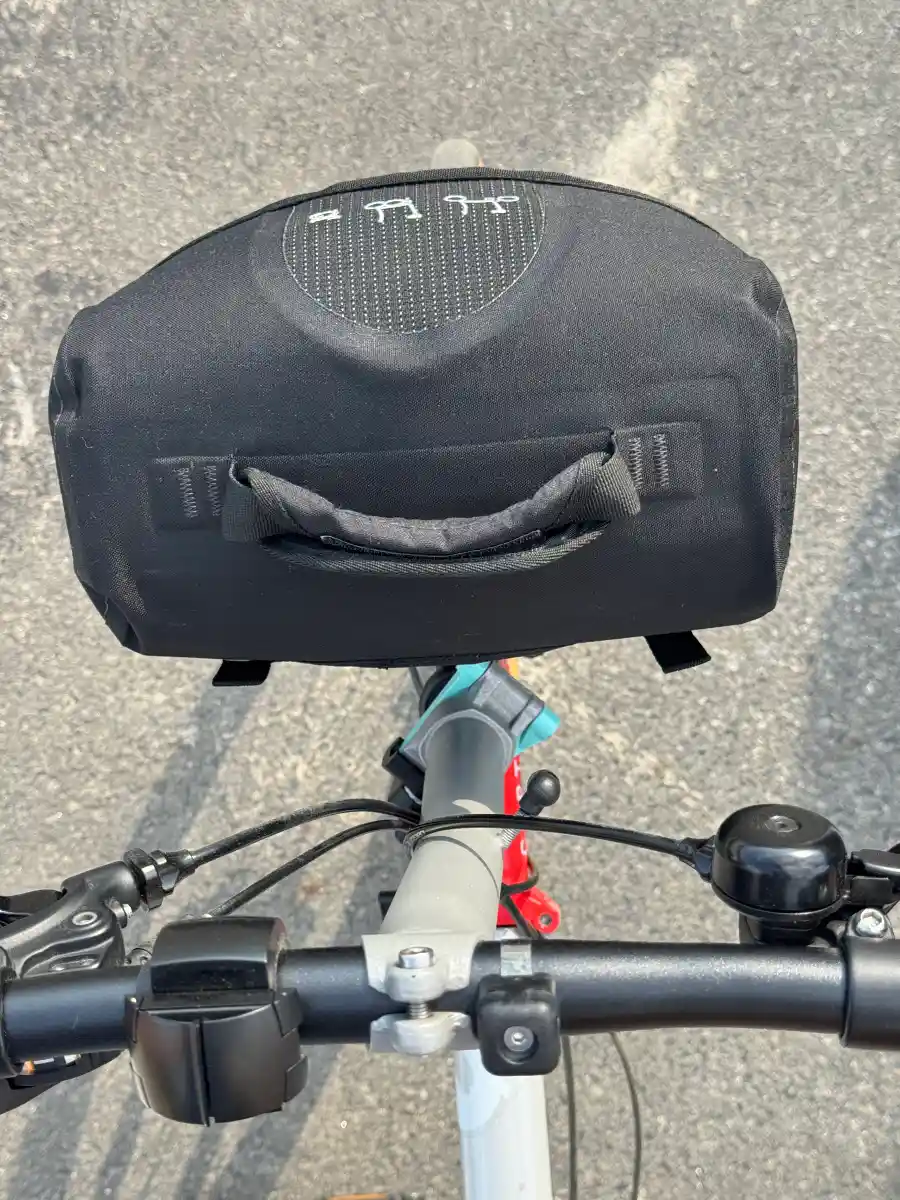 브롬톤 라이더 시점에서 바라본 Mini O Bag 장착 상태 — 핸들바 너머 프론트 캐리어 뷰