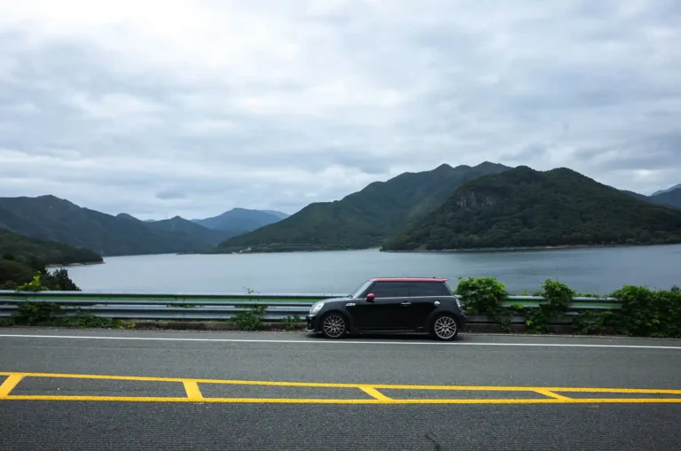 운문댐 수변 국도에 세운 MINI JCW R56, 배경에 운문호와 산세가 펼쳐져 있다