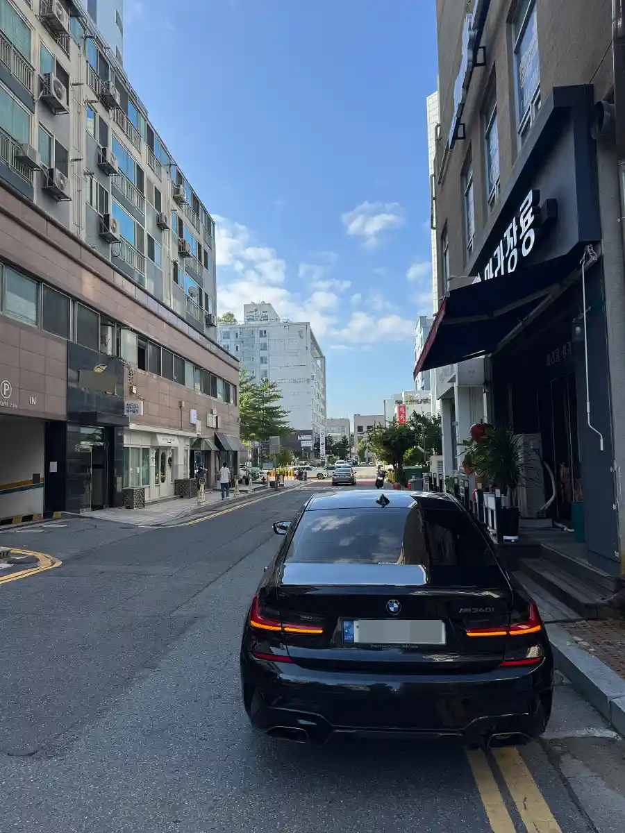 도심 골목에 정차된 검정 BMW M340i 후면 — 내연기관 오너의 시선으로 쓴 전기차 배터리 시리즈