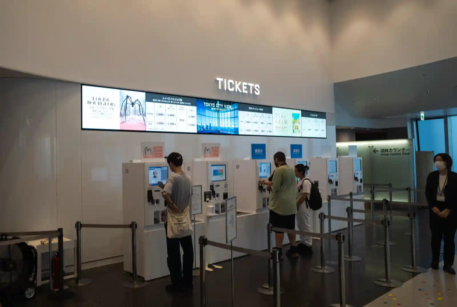 롯폰기 힐스 모리타워 도쿄 시티뷰 매표소 전경. TICKETS 사인 아래 키오스크 발권기가 늘어서 있고 방문객들이 티켓을 구매하고 있다