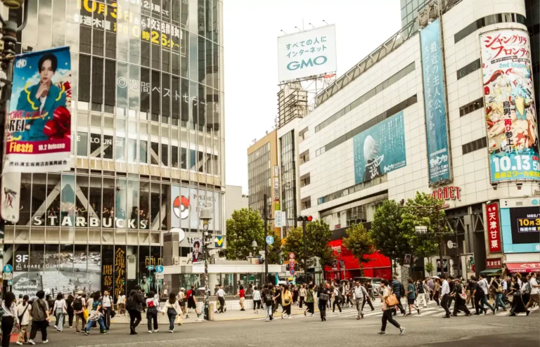 시부야 스크램블 교차로를 가로지르는 인파와 광고판으로 가득 찬 도쿄의 거리 풍경